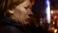 Woman in jacket Sits in car crying. night and rain, background blur