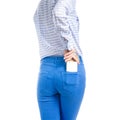 Woman in jeans and blue shirt put smartphone in pocket macro