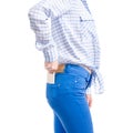 Woman in jeans and blue shirt put smartphone in pocket macro