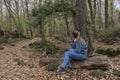 Woman with jeans fashion sitting on woods in the forest.Travel concept , people lifestyle in amazing landscape with copy space