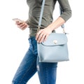 Woman in jeans and green shirt bag smartphone in hand macro Royalty Free Stock Photo