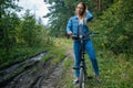 Woman in jeans riding on a bicycle at rural road Royalty Free Stock Photo