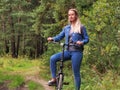 Woman in jeans riding on a bicycle at rural road Royalty Free Stock Photo