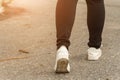 Close up of The woman jeans and sneaker shoes walking on the road Royalty Free Stock Photo