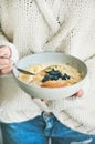 Woman in jeans and sweater eating oatmeal porriage Royalty Free Stock Photo