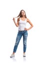 Woman in jeans and white singlet twirling hair, isolated Royalty Free Stock Photo