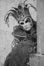 Woman in jester`s costume, mask and hat posing at the Church of San Giorgio Maggiore during Venice Carnvial Royalty Free Stock Photo