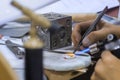 Woman jeweller, designer holding blowtorch and making handmade brooch - close up Royalty Free Stock Photo