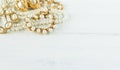 Woman Jewelry. Vintage jewelry background. Beautiful gold and pearl necklaces, bracelets and earrings on white wood. Flat lay,