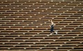 Woman jogging across bleacher seating Red Rocks Amphitheater in Morrison Colorado