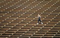 Woman jogging across bleacher seating Red Rocks Amphitheater in Morrison Colorado