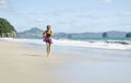 Woman jogging along a beautiful beach. Royalty Free Stock Photo