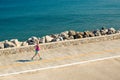 Woman jogging on city street at seaside