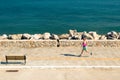 Woman jogging on city street at seaside