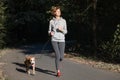 Woman jogging with dog in a park. Young female person with pet d Royalty Free Stock Photo