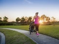 Woman jogging and exercising outdoors pushing her baby in a stroller