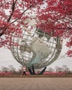 Woman jogging in front of the globe installation in the Flushing Meadows Corona Park in New York. Royalty Free Stock Photo