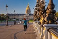 Woman jogging at the Pont Alexandre III bridge over the Seine river, Paris. France