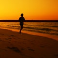 Woman jogging during Sunset over Jumeira beach in Dubai.