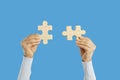 Woman joining two matching jigsaw puzzle pieces as metaphor for integration and solution Royalty Free Stock Photo