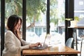 woman journalist freelancer working online on laptop, sitting at desk at home, looking at screen, typing, serious young Royalty Free Stock Photo