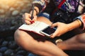 Woman journalist reporter with camera takes notes on a notebook