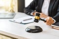 Woman judge hand holding gavel to bang on sounding block in the court room Royalty Free Stock Photo