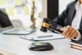 Woman judge hand holding gavel to bang on sounding block in the court room Royalty Free Stock Photo