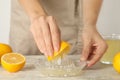 Woman juicing lemon at white wooden table, closeup