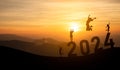 Woman jump happy new year 2024 concept, silhouette of woman jumping over barrier cliff and success with beautiful sunset Royalty Free Stock Photo