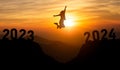 Woman jump happy new year 2024 concept, silhouette of woman jumping over barrier cliff and success from 2023 cliff to 2024 cliff Royalty Free Stock Photo