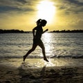 Woman jump / running on the beach at sunset. Royalty Free Stock Photo