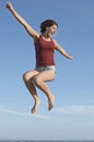Woman Jumping In Air Against Blue Sky Royalty Free Stock Photo