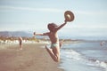 Woman jumping in the air on tropical beach,having fun and celebrating summer,beautiful playful woman jumping of happiness