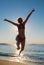 Woman jumping backlight on seashore Royalty Free Stock Photo