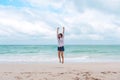 A woman jumping on the beach in front of the sea with feeling happy Royalty Free Stock Photo