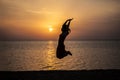Woman jumping beautiful silhouette against the sea and dawn Royalty Free Stock Photo