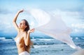 Woman jumping with cloth on a beach Royalty Free Stock Photo