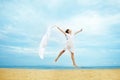 Woman jumping with cloth on a beach Royalty Free Stock Photo