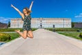 Woman jumping with happiness with arms up. Royal Palace of Caserta in Italy. Travel in Italy.