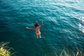 Woman jumping off cliff into the sea. Royalty Free Stock Photo