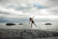 Woman jumping on a rock at sunset on Bakovern Beach, Cape Town.