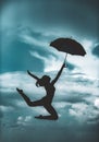Woman jumping with umbrella. Ballet dancer isolated on sky background. Expressive artistic dance concept. Woman jump Royalty Free Stock Photo