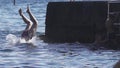 Woman jumps from a pier into sea