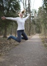 The woman jumps on the track in the early spring wood Royalty Free Stock Photo