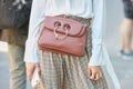 Woman with Jw Anderson brown leather bag and white shirt before Fendi fashion show, Milan Fashion Week
