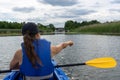 Woman in a kayak on a beautiful lake points to the reeds and shore