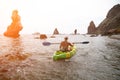 Woman kayak sea. Happy tourist takes sea photo in kayak canoe for memory. Woman traveler poses amidst volcanic mountains