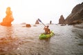 Woman kayak sea. Happy tourist takes sea photo in kayak canoe for memory. Woman traveler poses amidst volcanic mountains Royalty Free Stock Photo