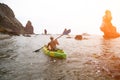 Woman kayak sea. Happy tourist takes sea photo in kayak canoe for memory. Woman traveler poses amidst volcanic mountains Royalty Free Stock Photo